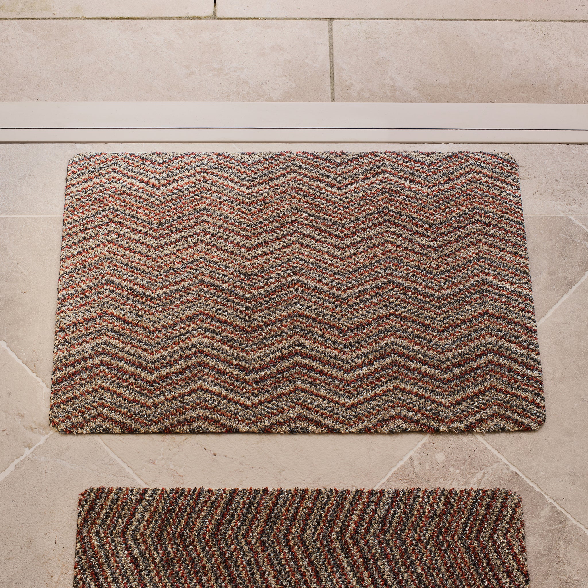 Candy Zig Zag Cotton Doormat with zig zag pattern, styled in a entryway.