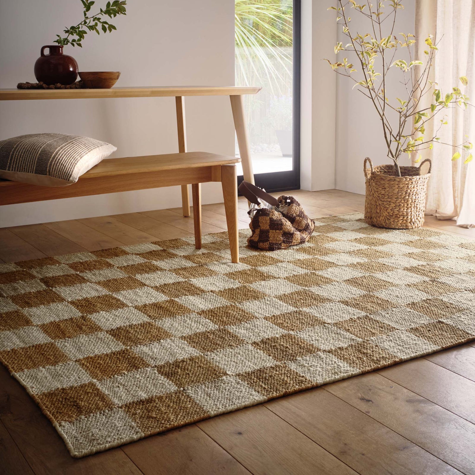 Checkerboard Jute Natural Rug with natural and brown checkerboard pattern., styled on wooden flooring.