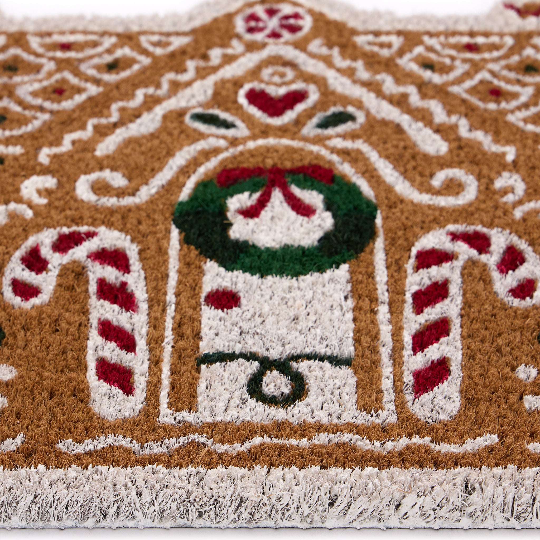 Discover the Christmas Gingerbread Cottage Coir Doormat- a coir doormat shaped as a gingerbread house decorated with sweets and icing. 