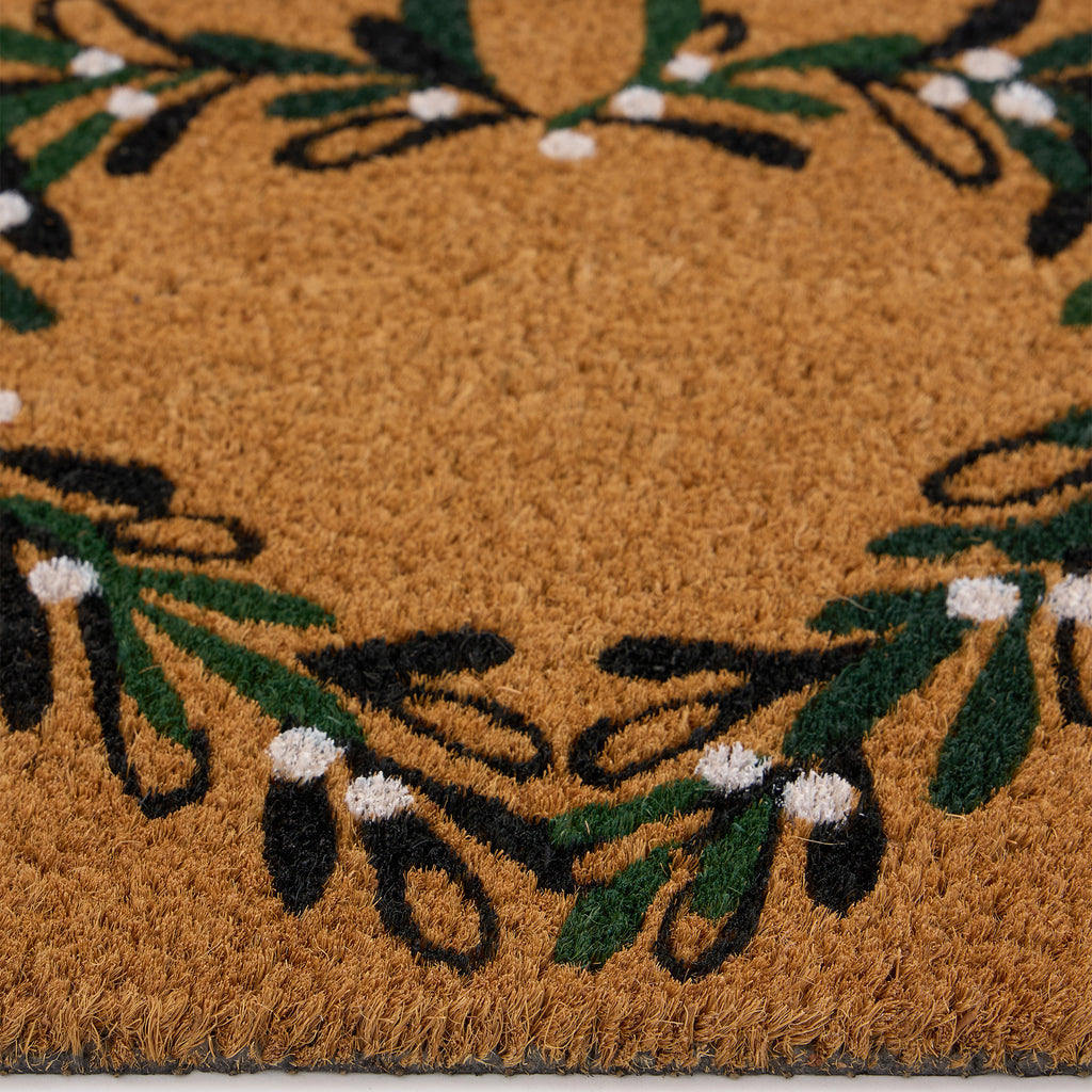 Discover the Christmas Mistletoe Heart Coir Doormat- a coir doormat featuring a heart wreath decorated with mistletoe. 