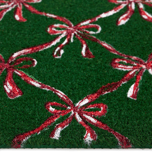 Discover the Christmas Festive Bows Coir Doormat- a coir doormat featuring pink bows against a green background. 