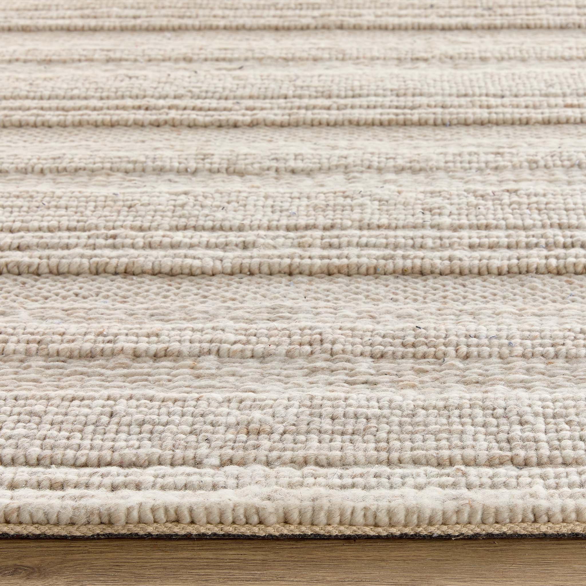 Close-up of the Chunky Knit Cream Wool Rug showing the pile height and the knitted pattern design.