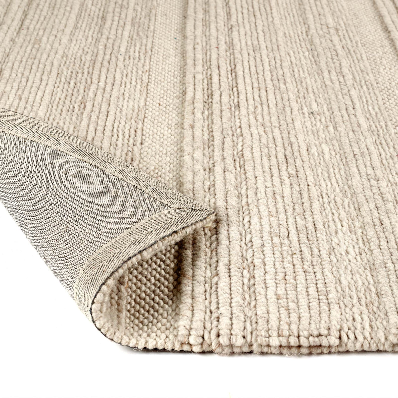 Close-up of the Chunky Knit Cream Wool Rug showing backing and the knitted design.