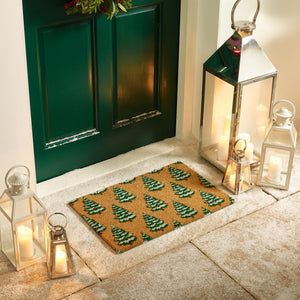Christmas Trees Coir Doormat with a snow dusted Christmas tree design, styled in a doorway.