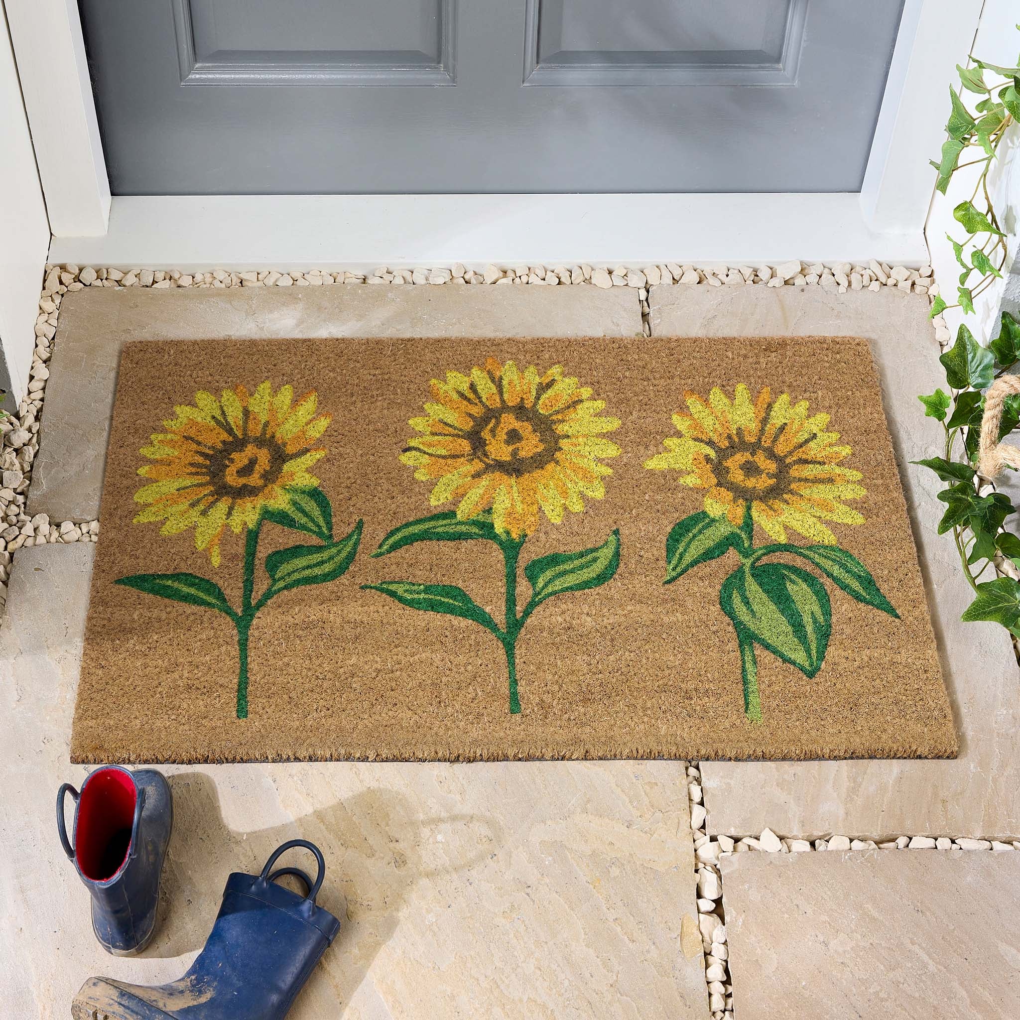 Sunflower Coir Doormat with a floral design, styled in doorway.