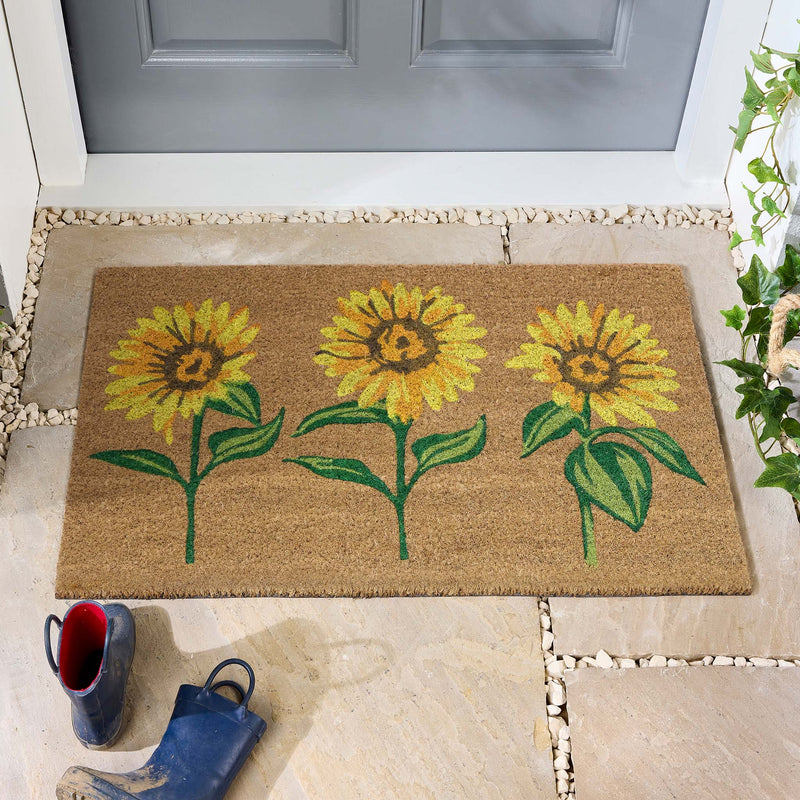 Sunflower Coir Doormat with a floral design, styled in doorway.