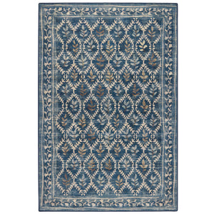 A rectangular area rug with a traditional ikat-style pattern in shades of blue, beige, and muted brown, shown flat against a white background.