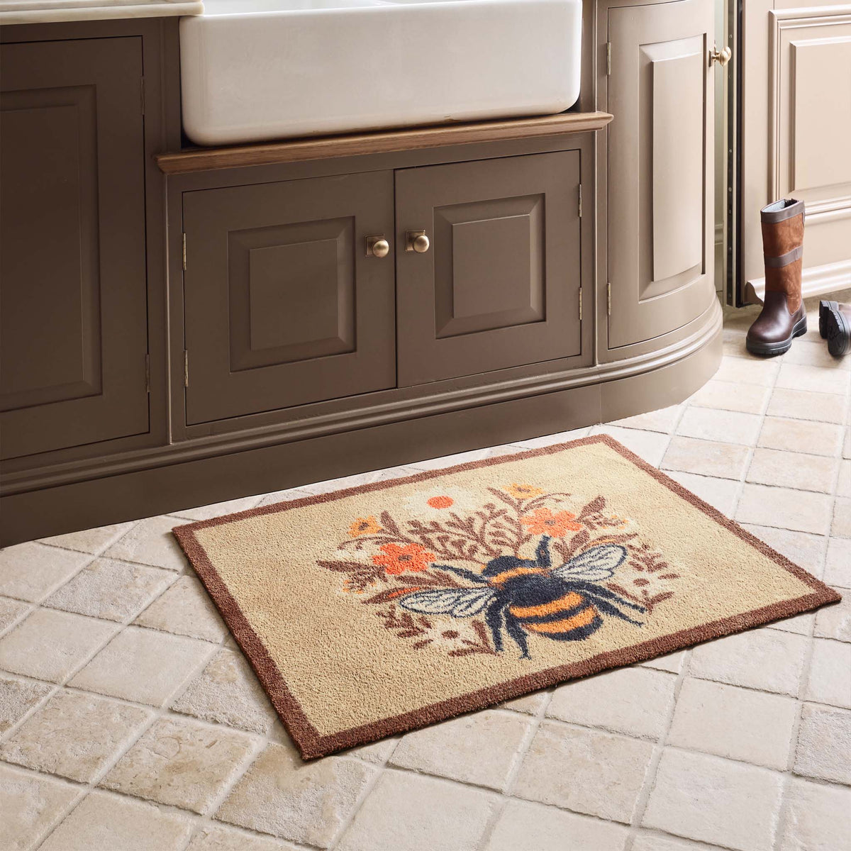 Floral Bee Beige Charity Doormat with a floral bee design, styled on tiled floor. 