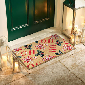 HO HO HO Coir Doormat with a fun Christmas design, styled in a doorway.