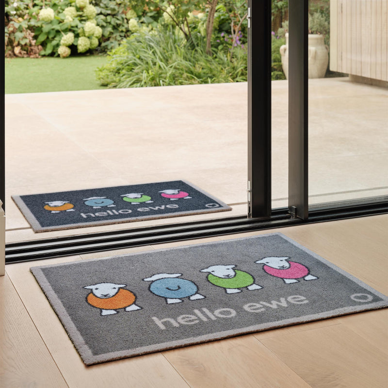 Hello Ewe Herdy Washable Doormat, with a fun design, styled in a doorway.