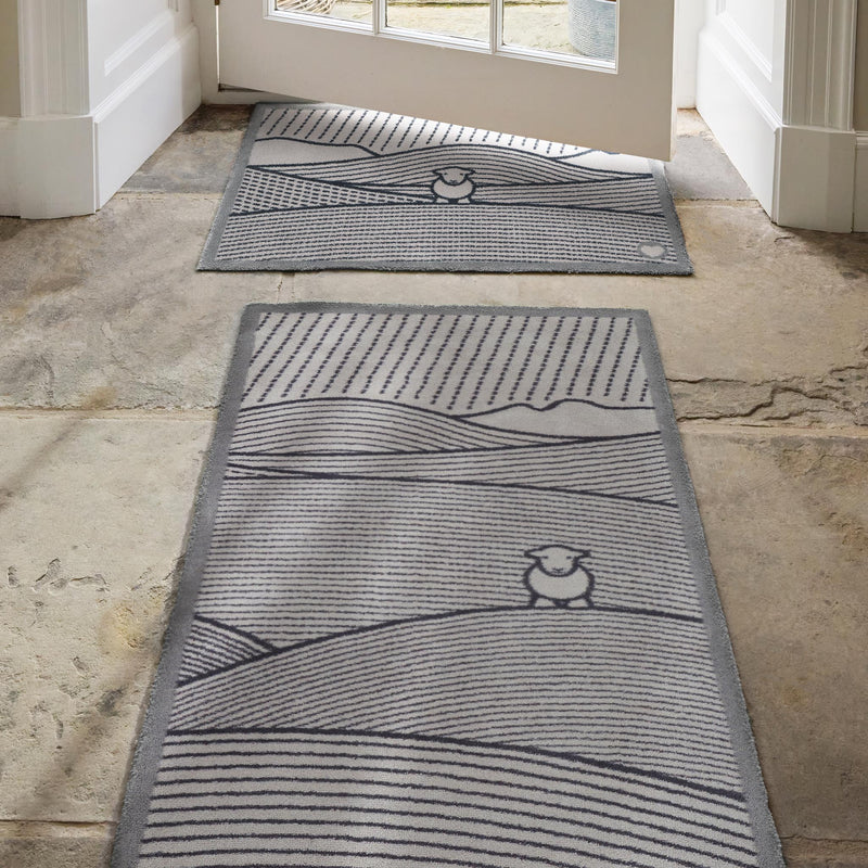 Herdy Lines Washable runner- a 100% recycled cotton runner featuring an artistic arrangement of grey and black lines forming a field, with the iconic Herdy sheep sitting peacefully within.