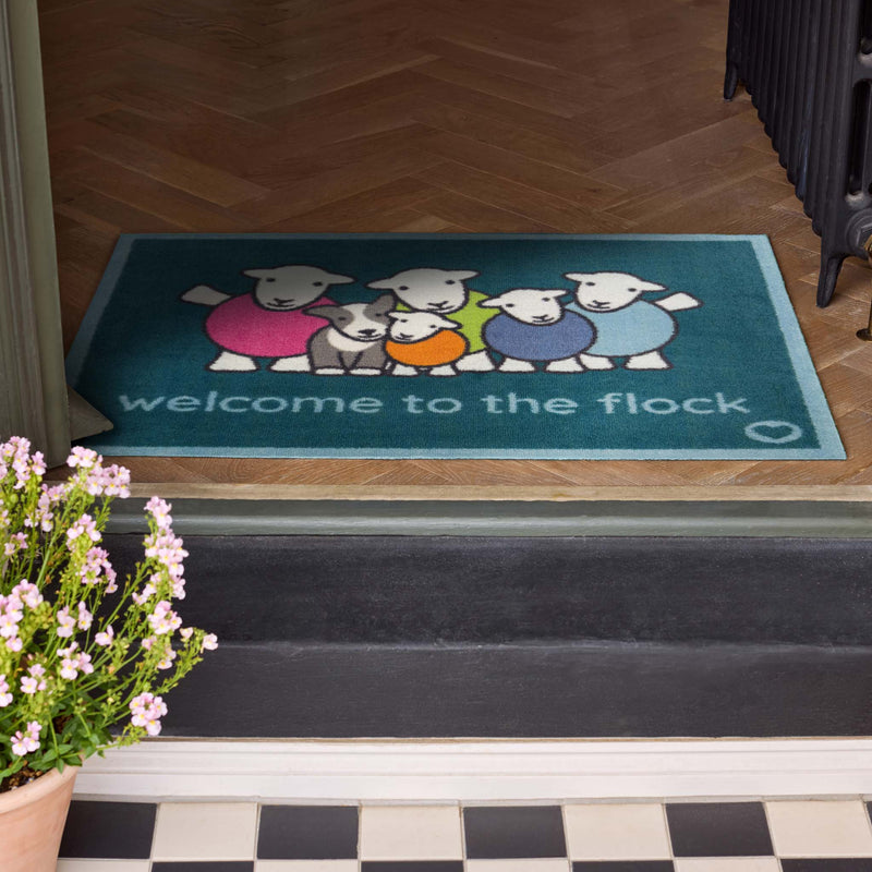 Flock Herdy Blue Washable Doormat with a fun herdy design, styled in a doorway.