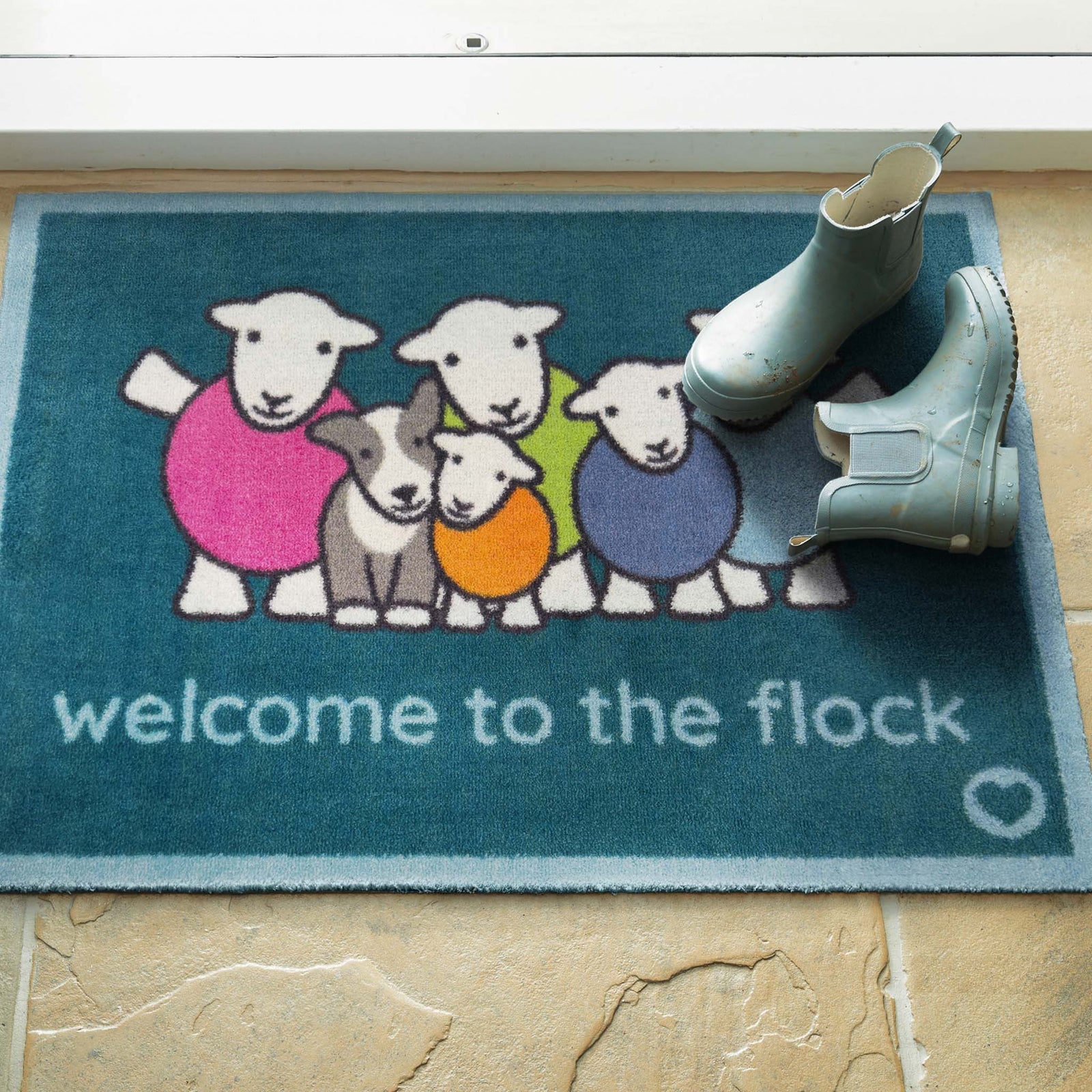 Flock Herdy Blue Washable Doormat with a fun herdy design, styled in a doorway.