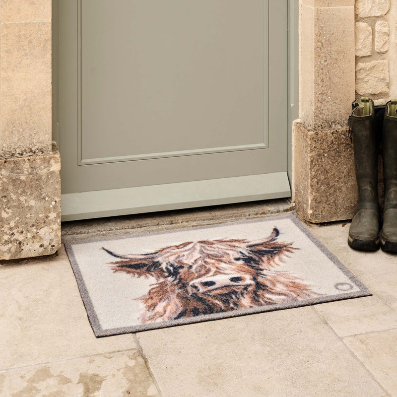 Heritage Highland Cow Grey Outdoor Doormat with a highland cow design, styled in a doorway.
