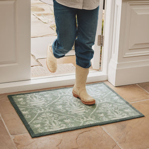 Highgrove Damask Silver Green Washable Doormat with a traditional style pattern, styled on tiled flooring.