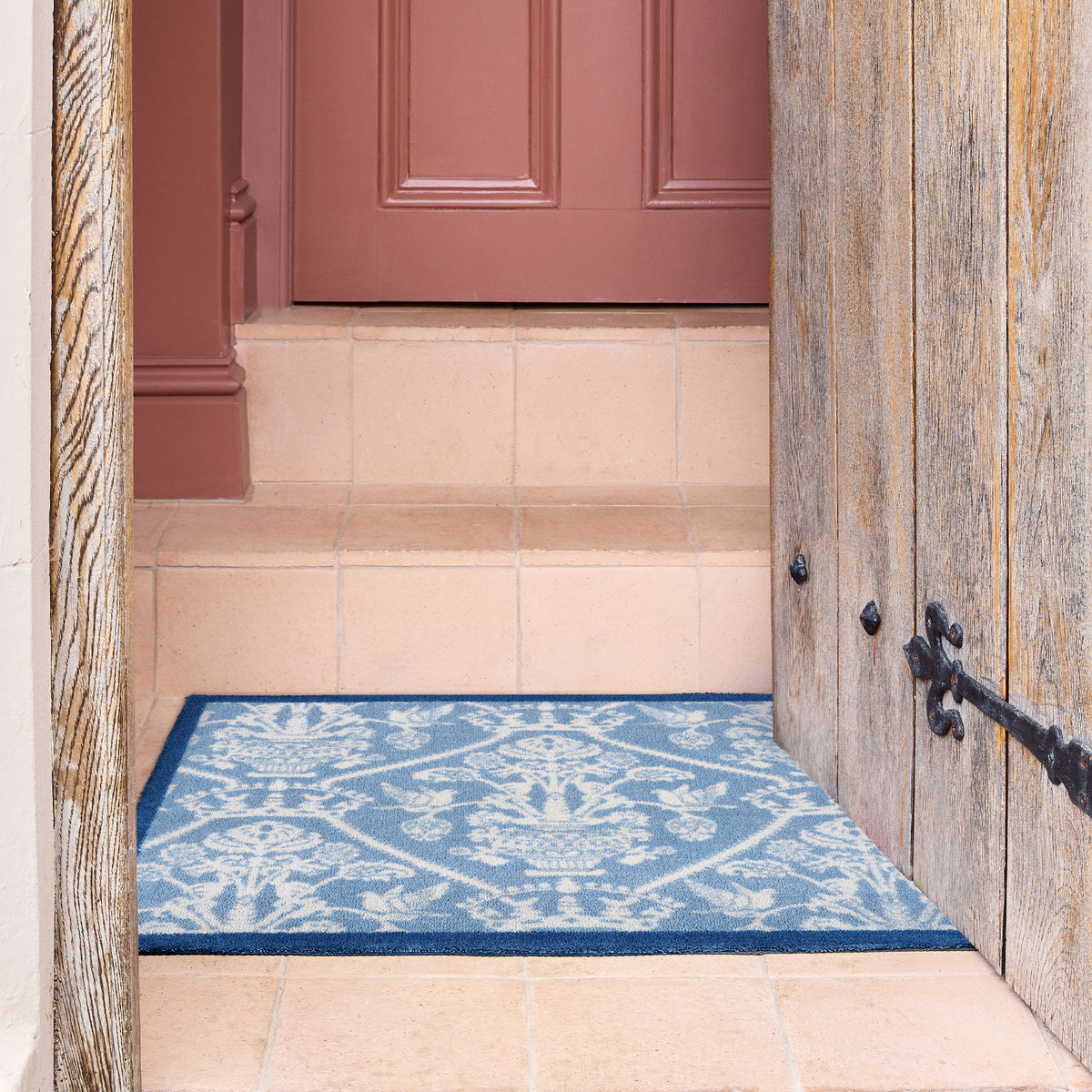 Highgrove Damask Tetbury Blue Washable Doormat with a traditional style pattern, styled on tiled flooring.