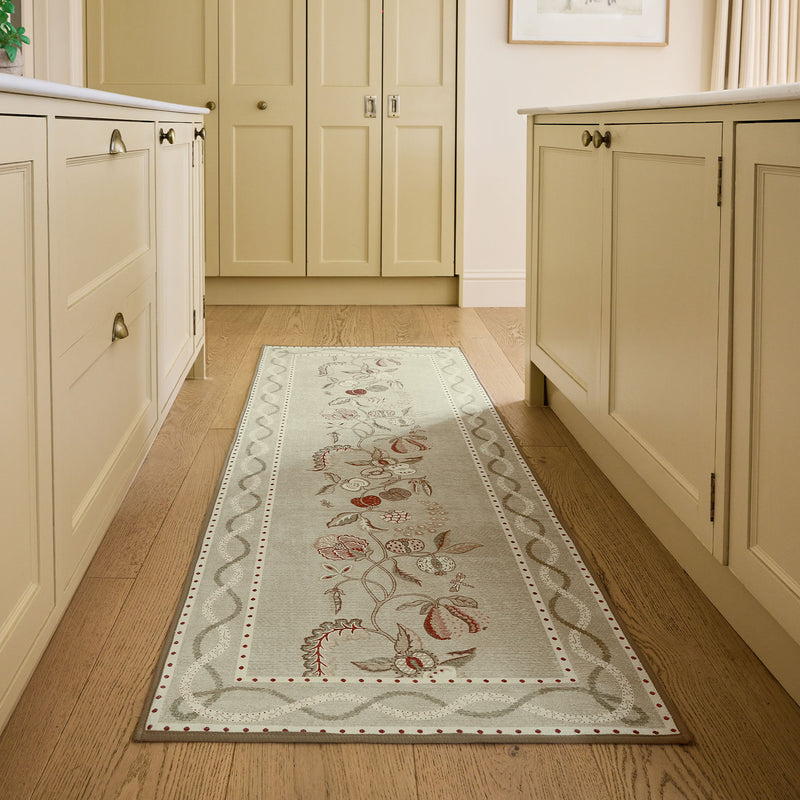 Kitchen Garden Olive & Russet Eco-Washable Runner with a floral design, stlyed on wooden flooring.