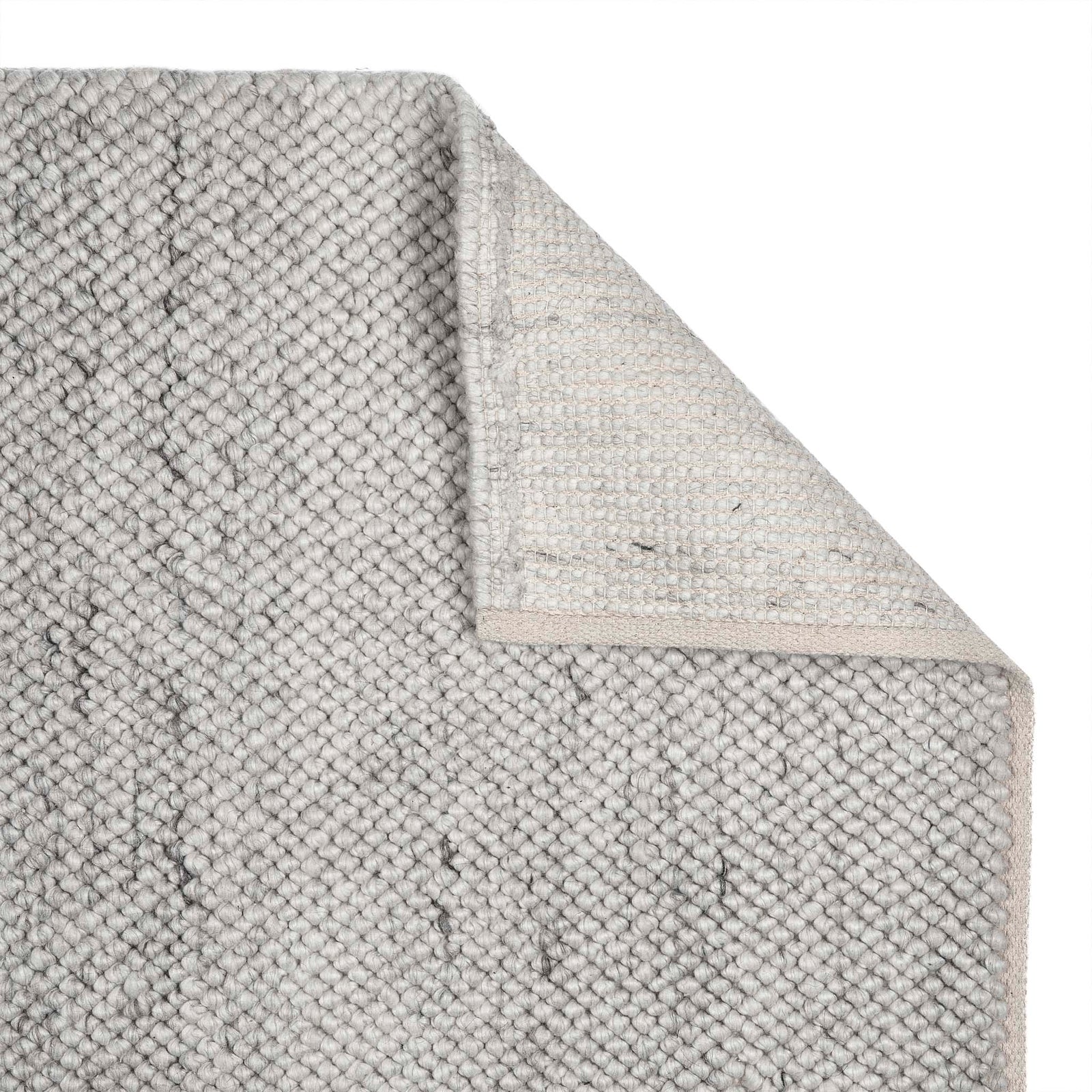 Close up of La Playa Silver Grey Rug showing its backing and its textured design.