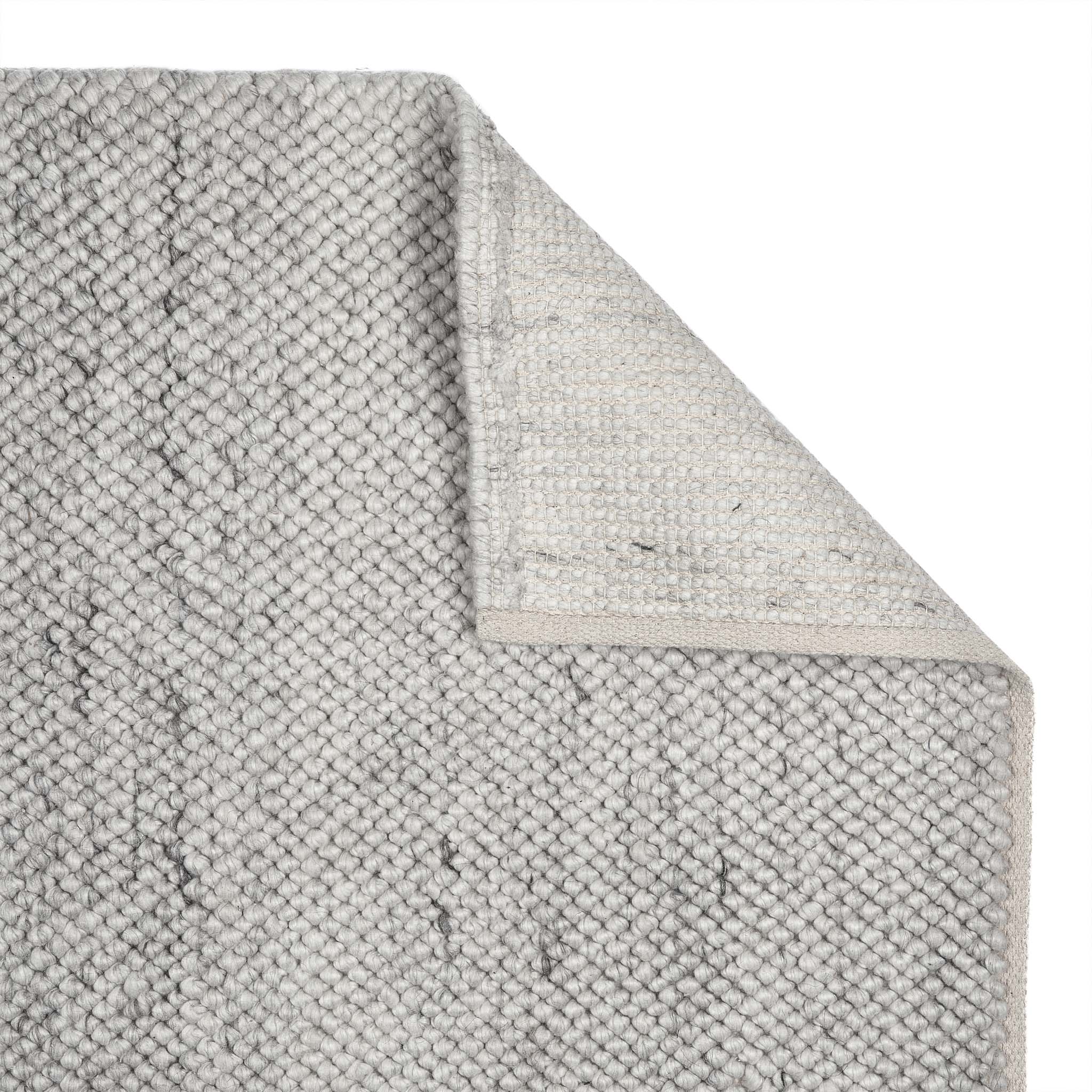 Close up of La Playa Silver Grey Rug showing its backing and its textured design.