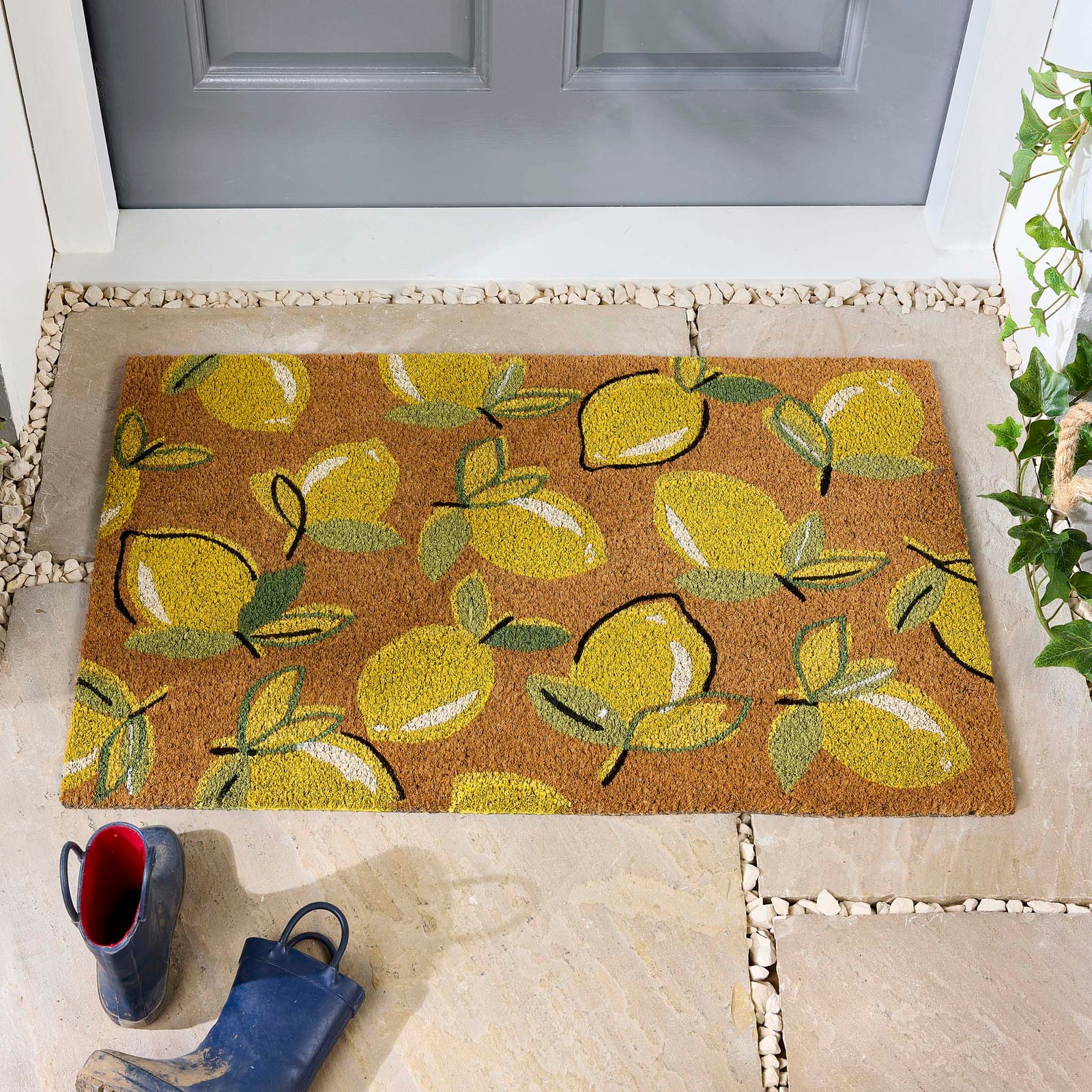 Lemons Yellow Coir Doormat with a multi-directional lemon pattern, styled in a doorway.