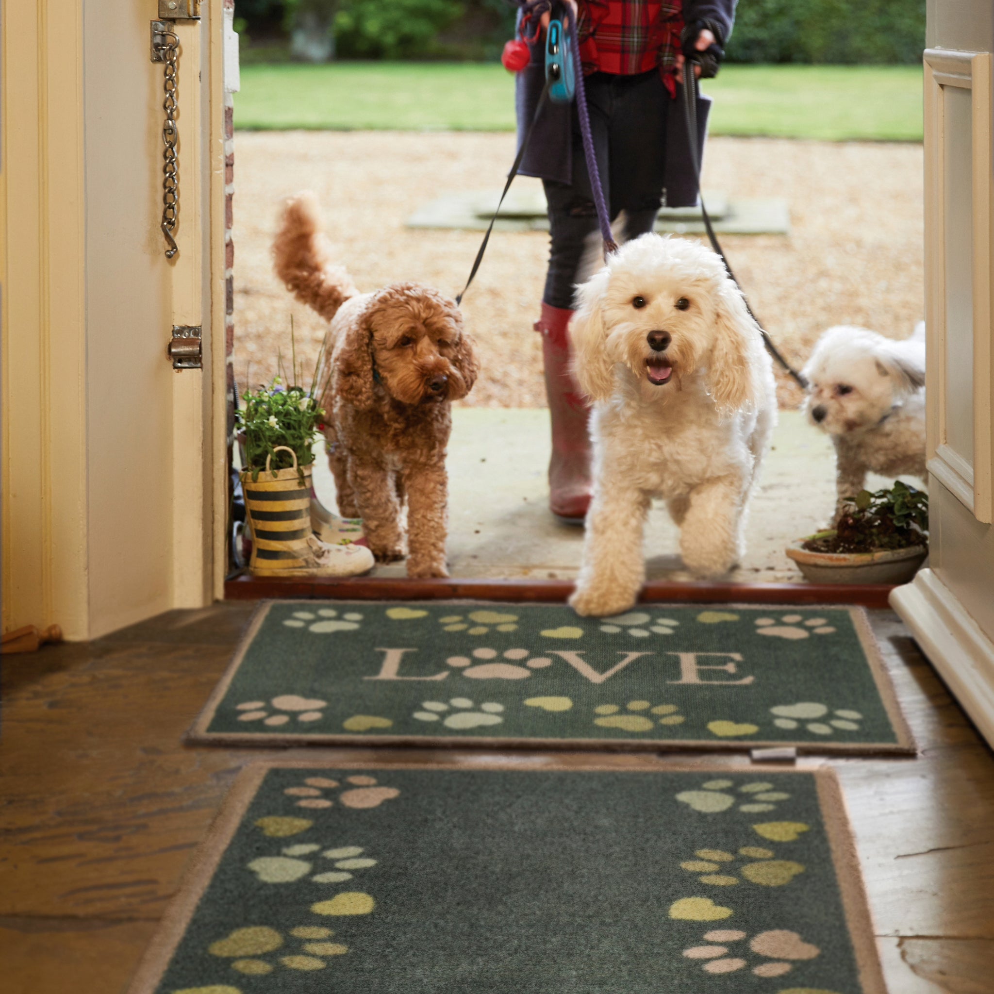 Love Paws Green Washable Runner in Green- a 100% recycled cotton runner featuring paw prints in shades of blue and green along the long sides of the runner. 