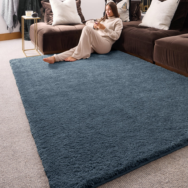 My Lux Smoke Blue Washable Rug in a solid dark blue colour, styled in a living room.