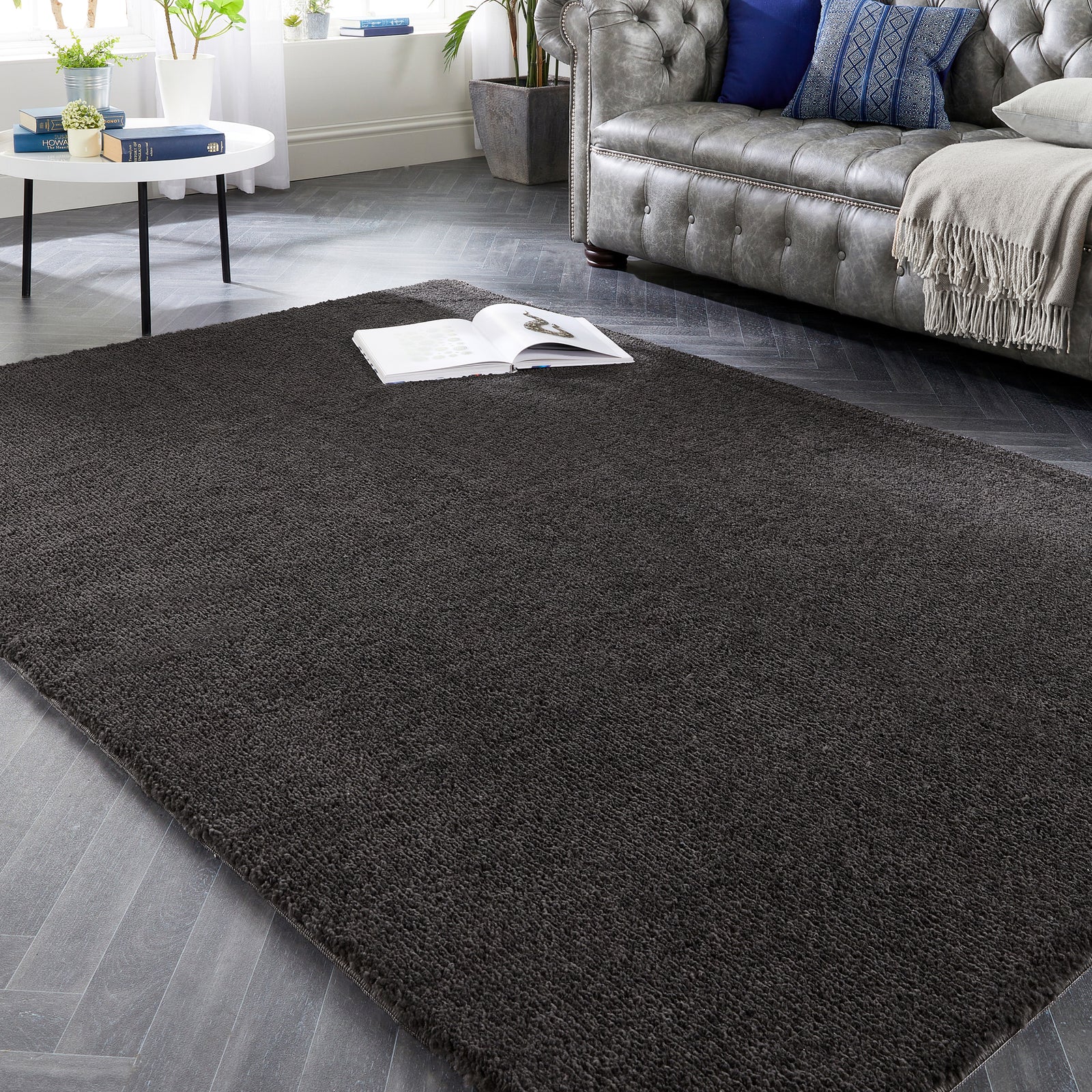 My Lux Charcoal Grey Washable Rug in a solid dark grey colour, styled in a living room.