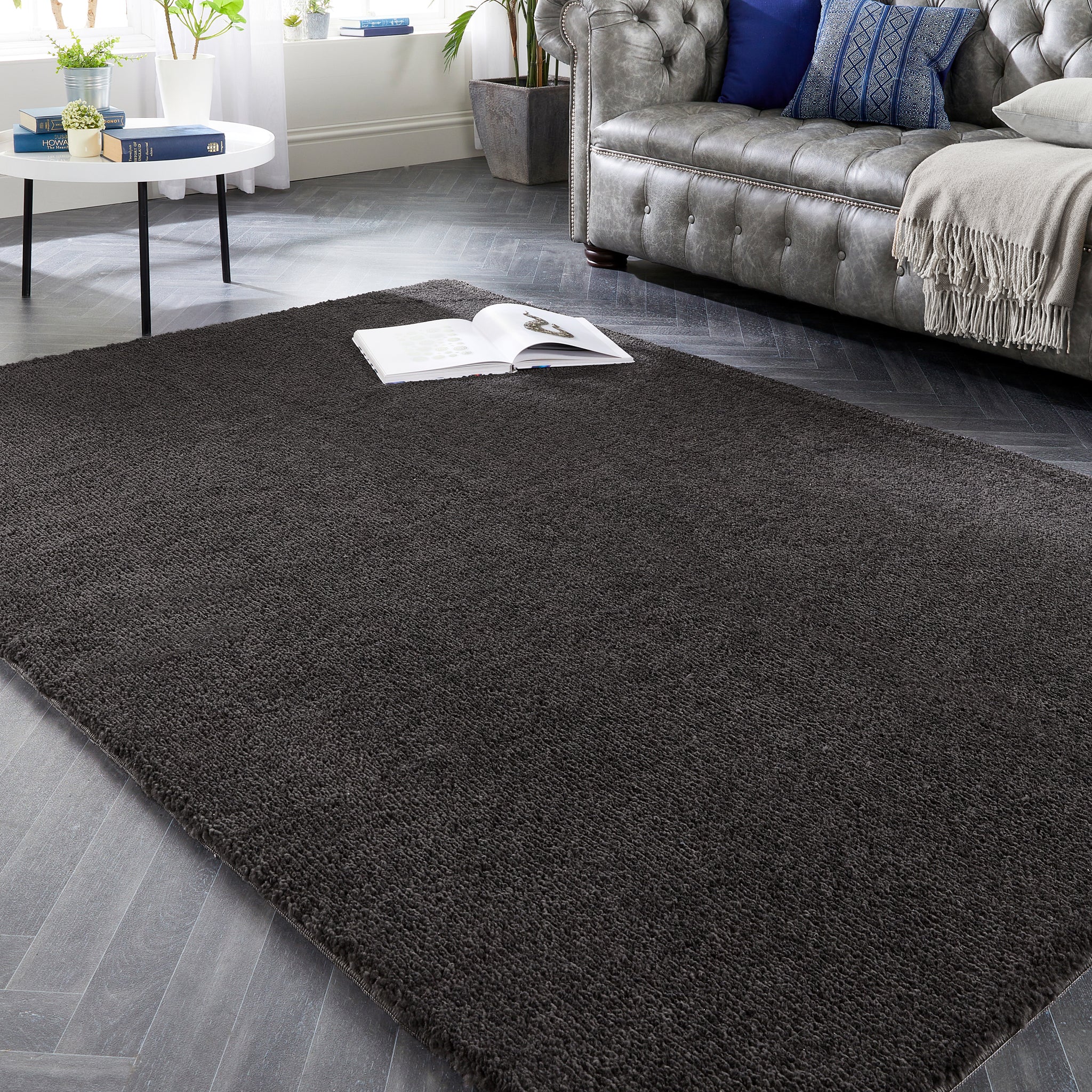 My Lux Charcoal Grey Washable Rug in a solid dark grey colour, styled in a living room.