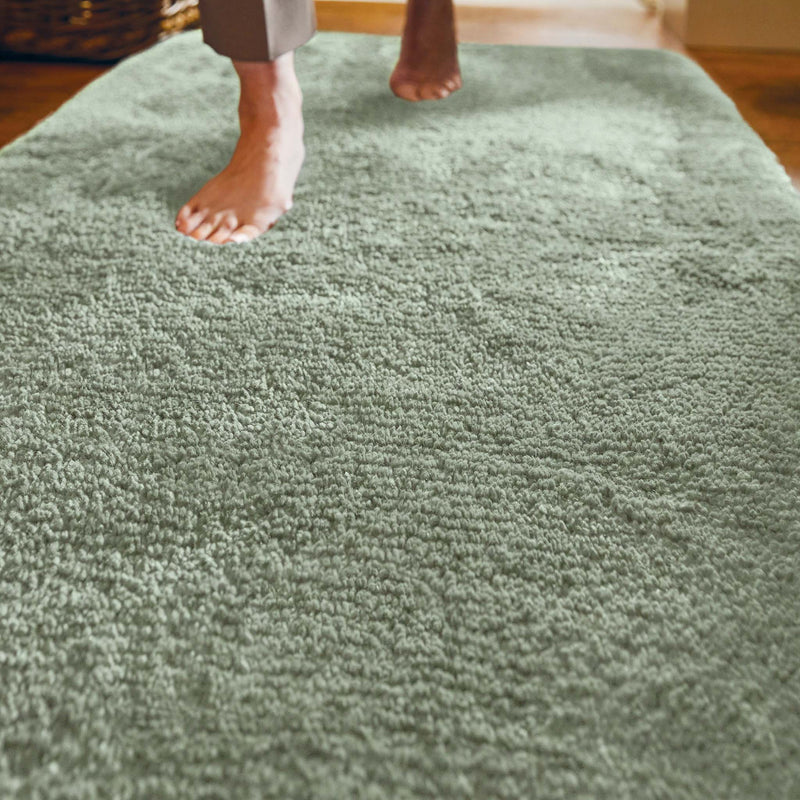 Luxe Green Shaggy Runner with a shaggy green pile, styled on wooden flooring. 