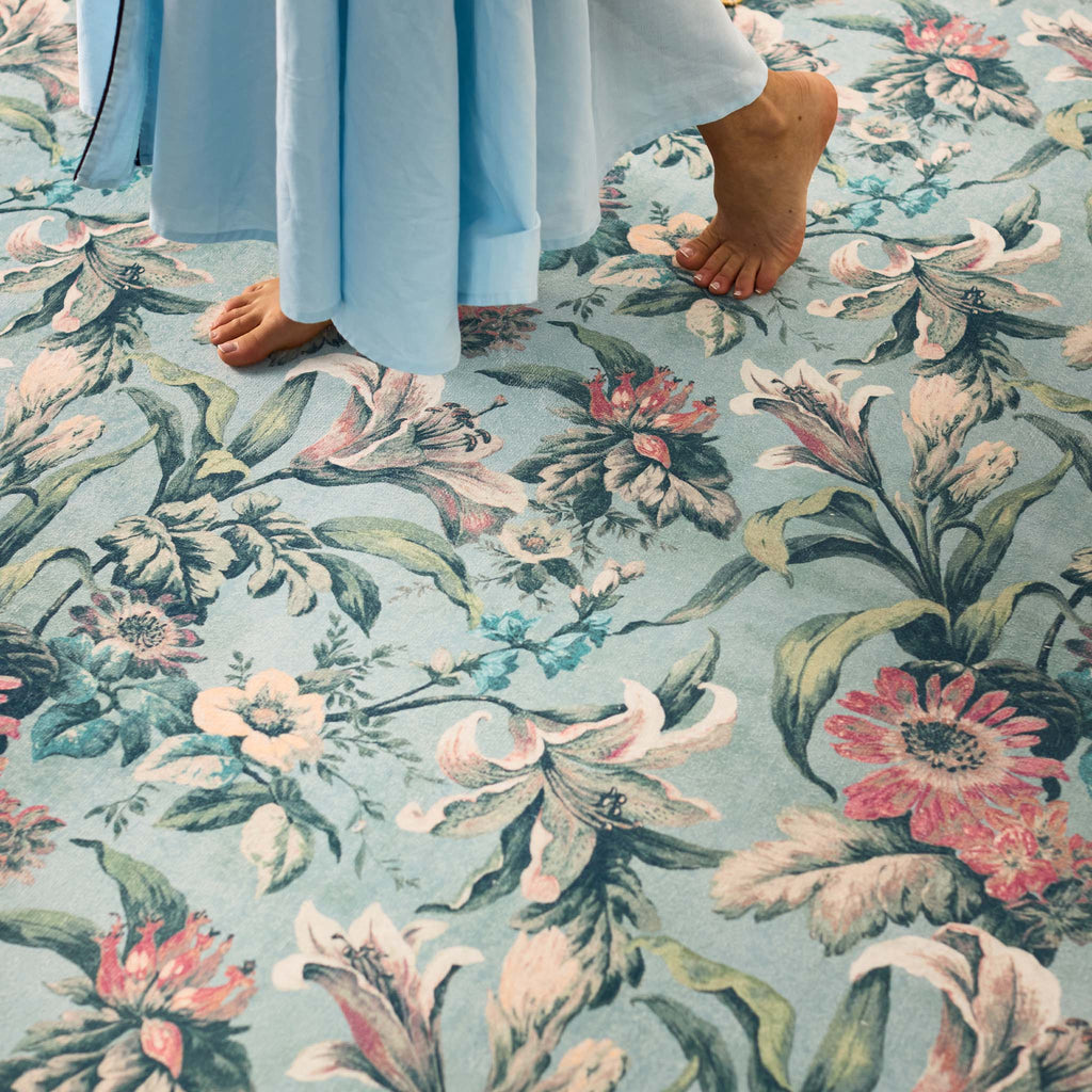 Close-up of Lys Blue Eco-Washable Rug with a floral design. 