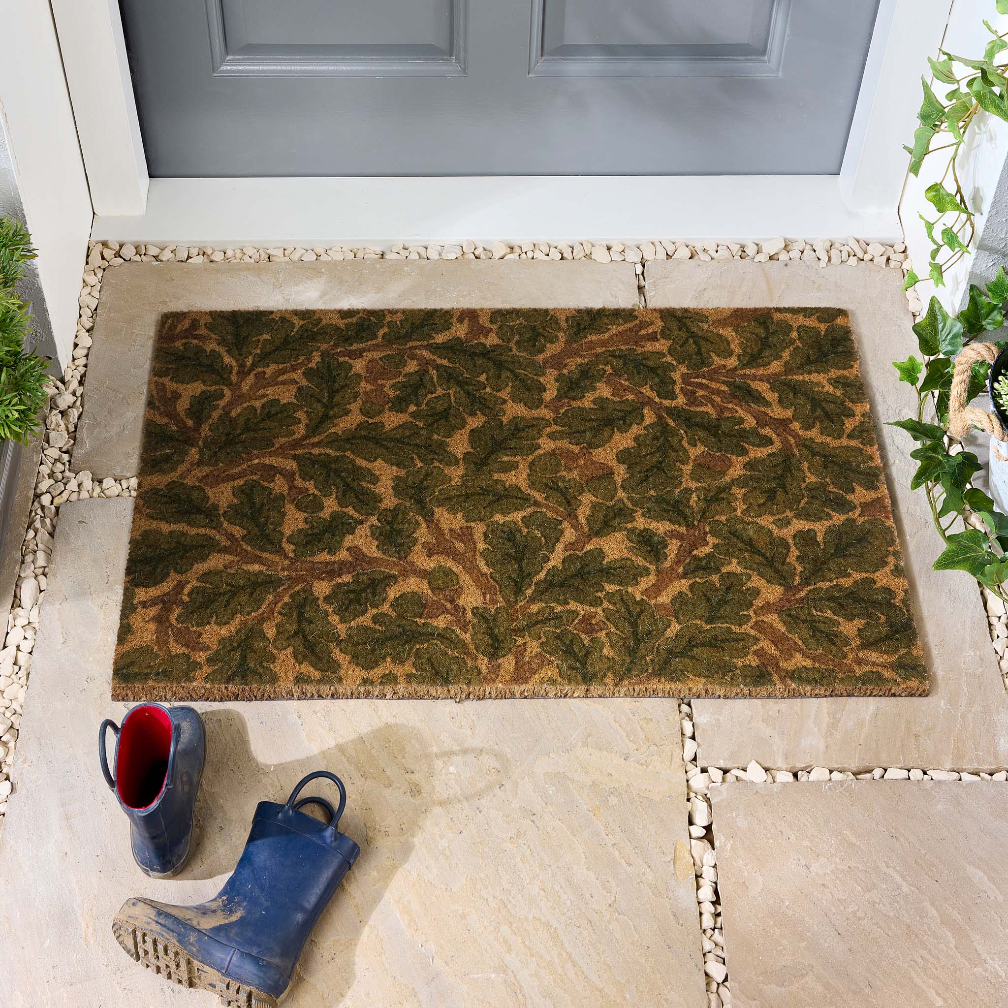 Morris & Co. Oak Green Brown Coir Doormat with a leaf pattern, styled in a doorway.