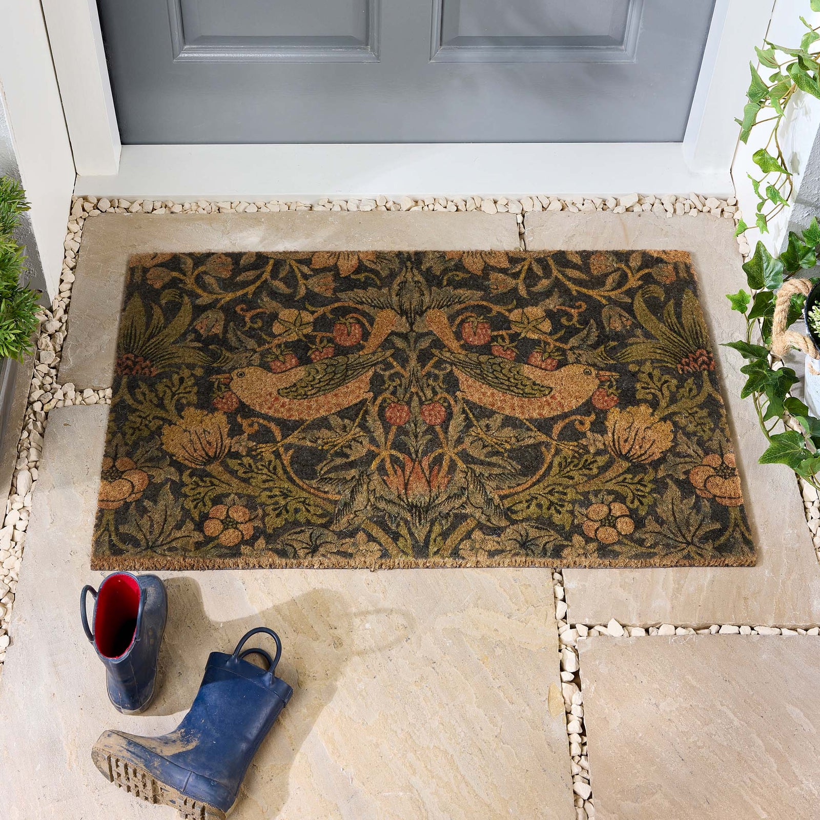 Morris & Co. Stawberry Thief Navy Blue  Coir Doormat with a nature inspired pattern, styled in a doorway.