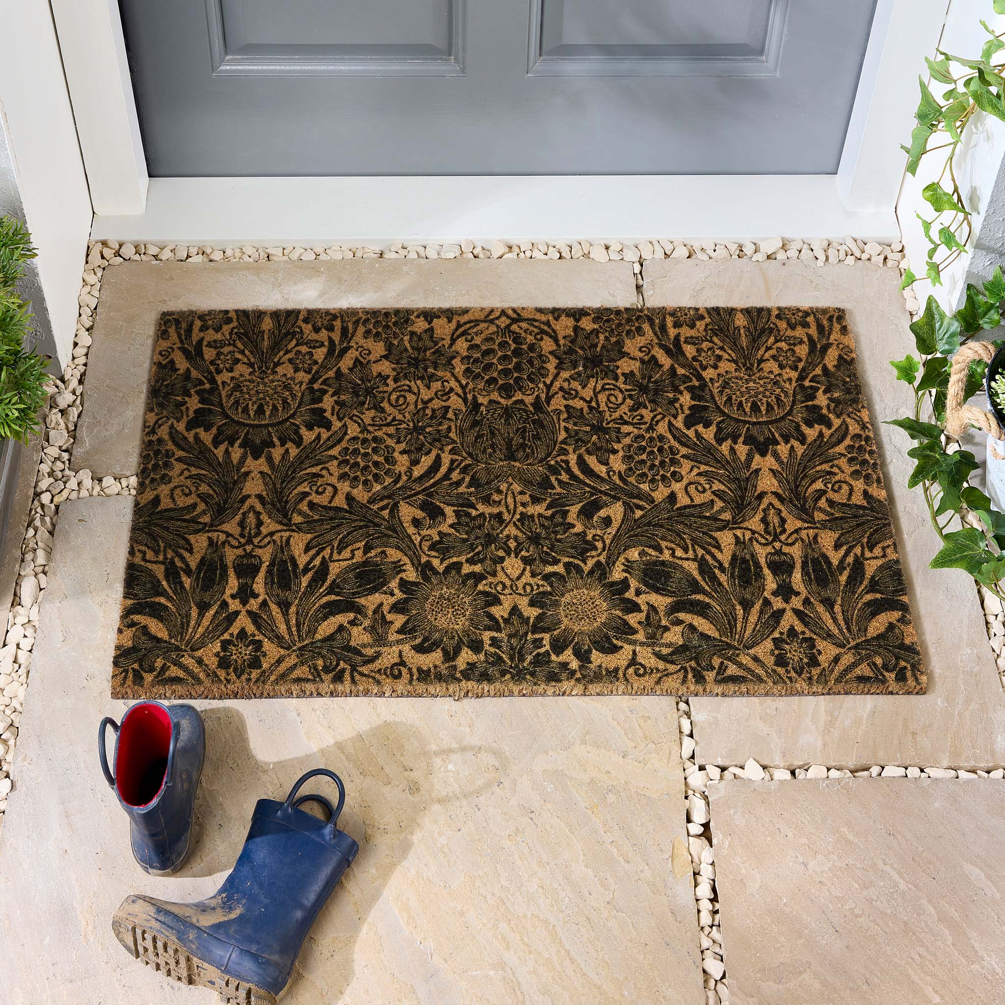 Morris & Co. Sunflower Black Coir Doormat with a floral inspired pattern, styled in a doorway.