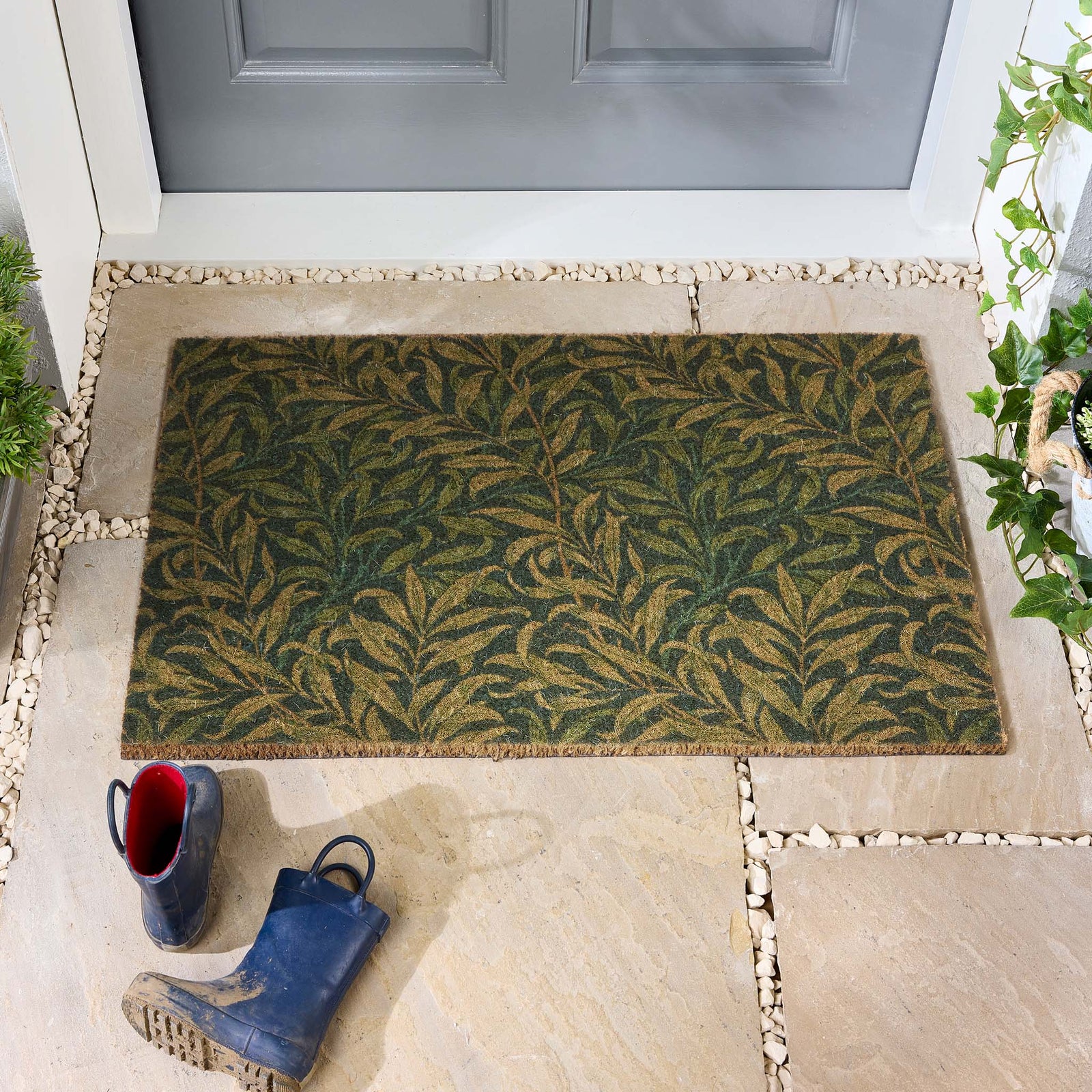 Morris & Co. Willowbough Green Coir Doormat with a leaf inspired pattern, styled in a doorway.