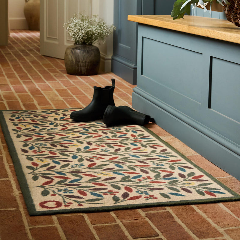  Olive Branch Washable Runner in a light brown- a 100% recycled cotton runner featuring branches adorned with multicoloured leaves and olives.