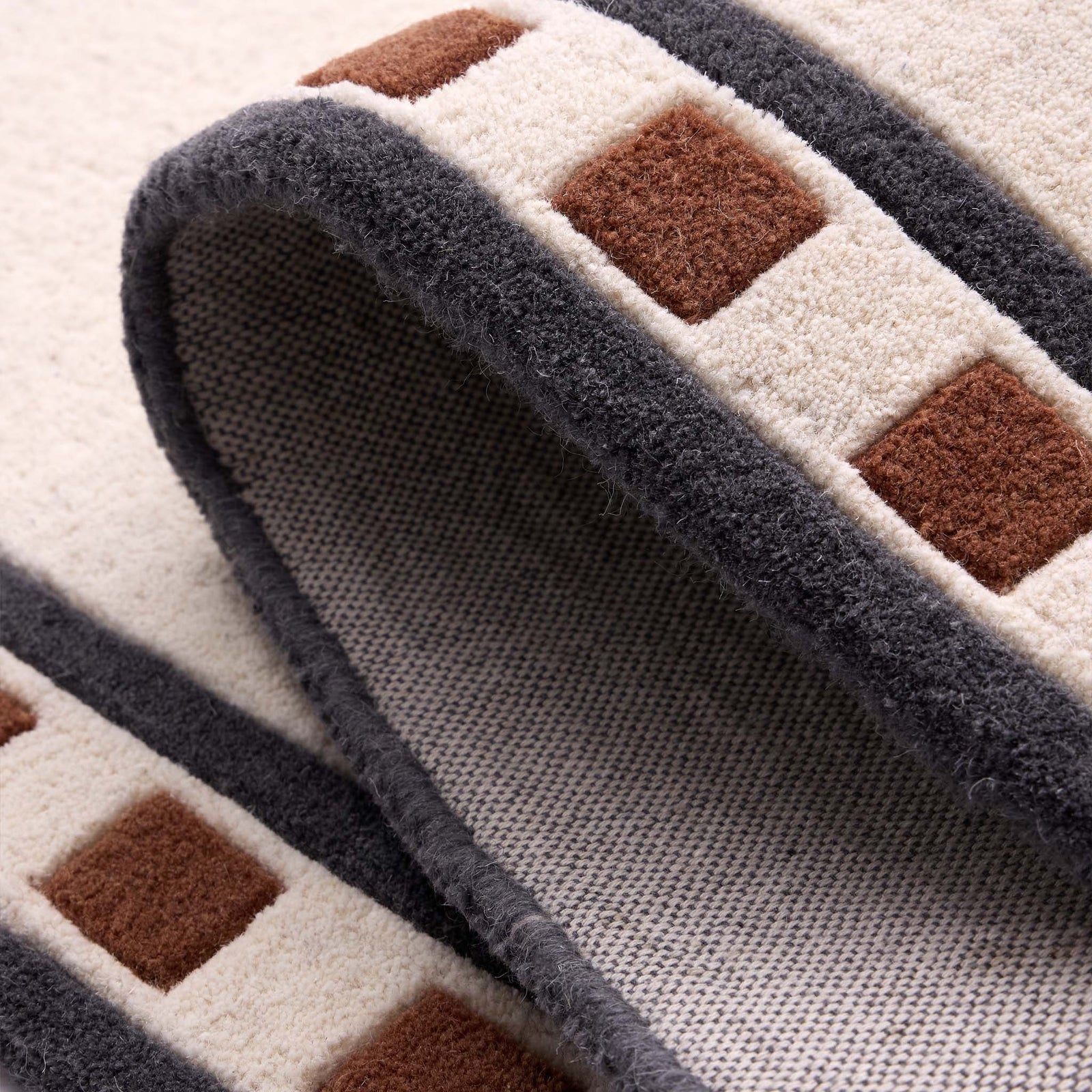 Borderline Natural Rug- a 100% wool cut pile rug featuring a brown and black geometric border. 