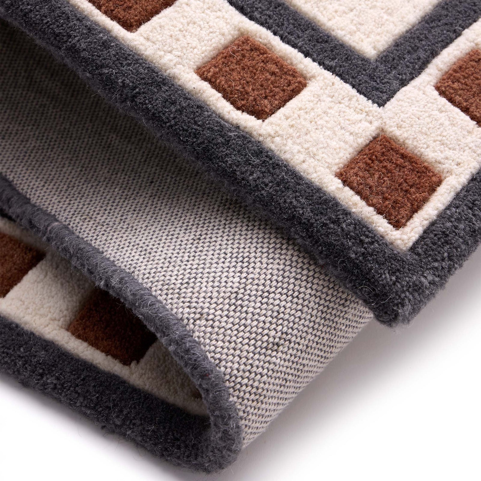 Borderline Natural Rug- a 100% wool cut pile rug featuring a brown and black geometric border. 