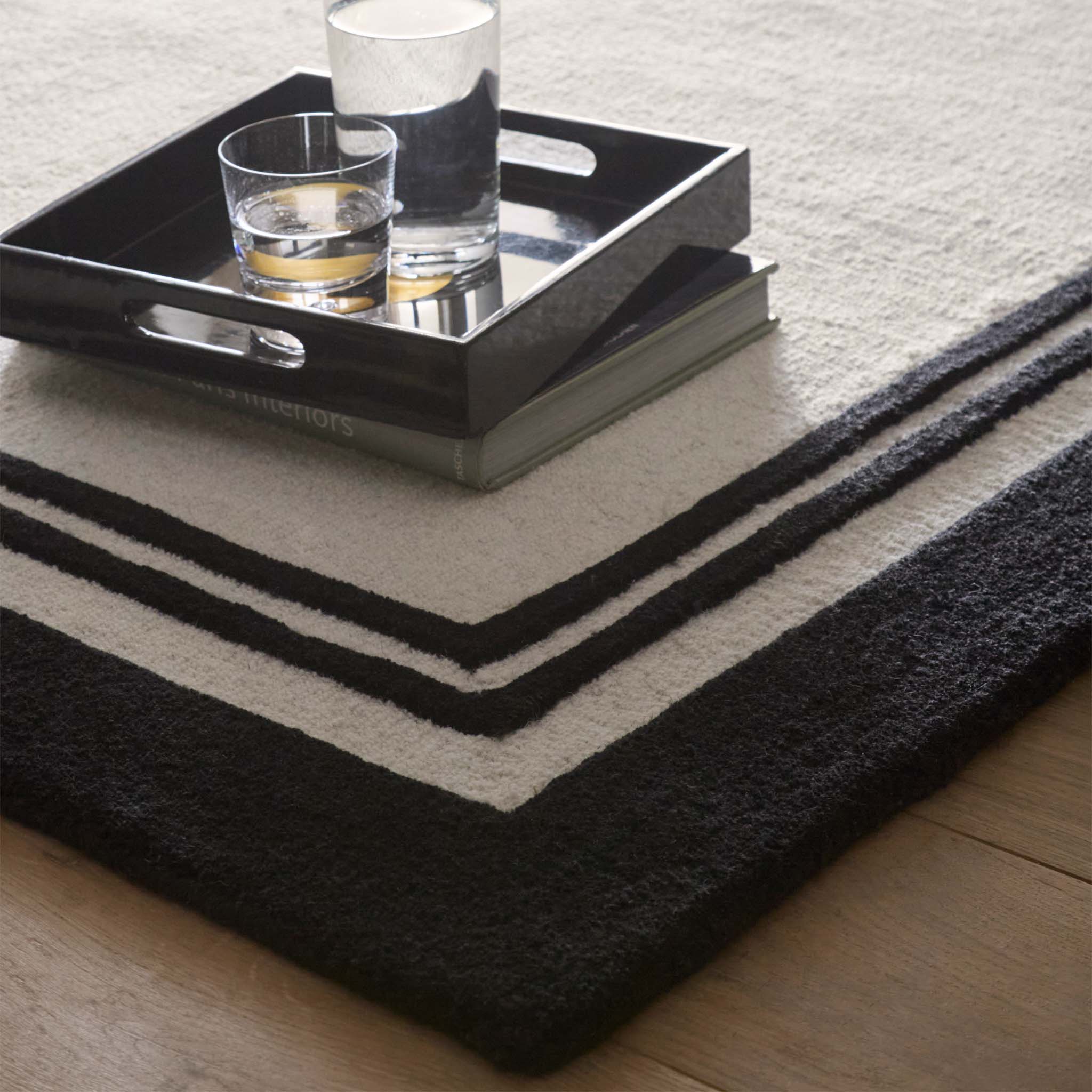 Close-up of Piper Monochrome Wool Rug with a black two border design.