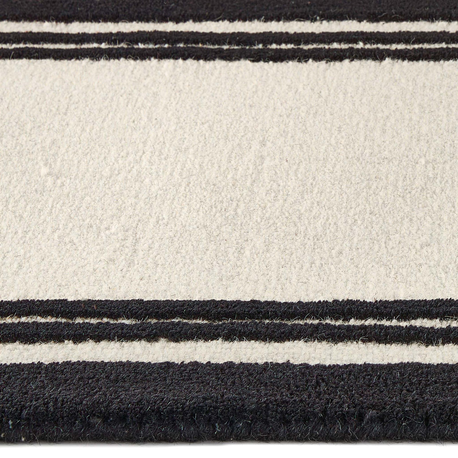 Close up of Piper Monochrome Wool Runner showing pile height and  black two border design.