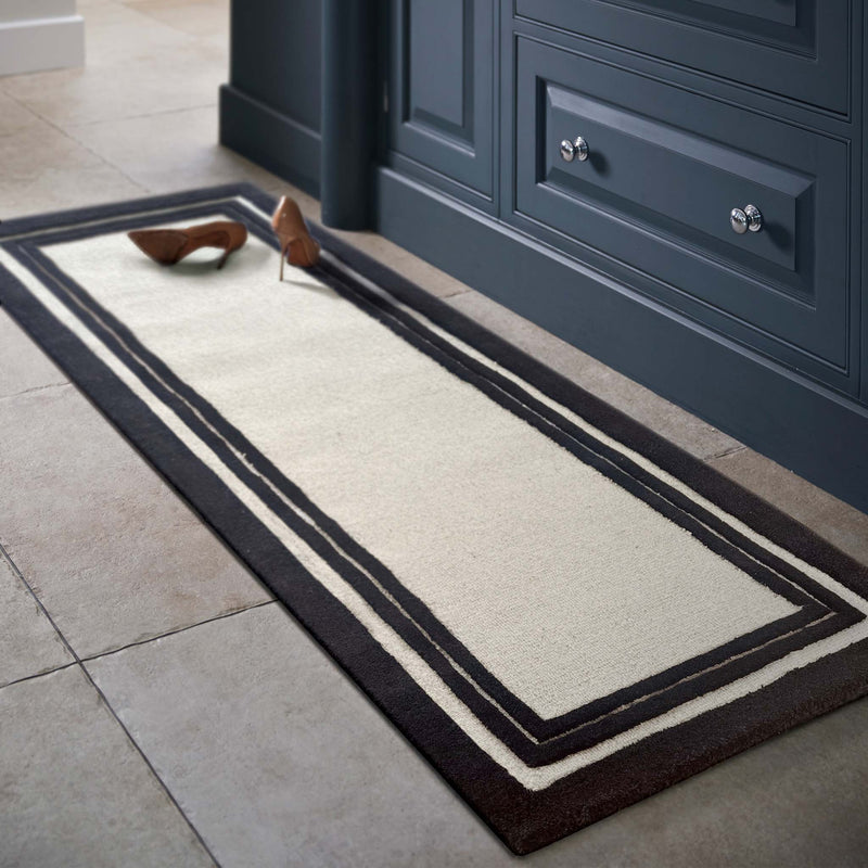 Piper Monochrome Wool Runner with a black two border design, styled in a entryway.