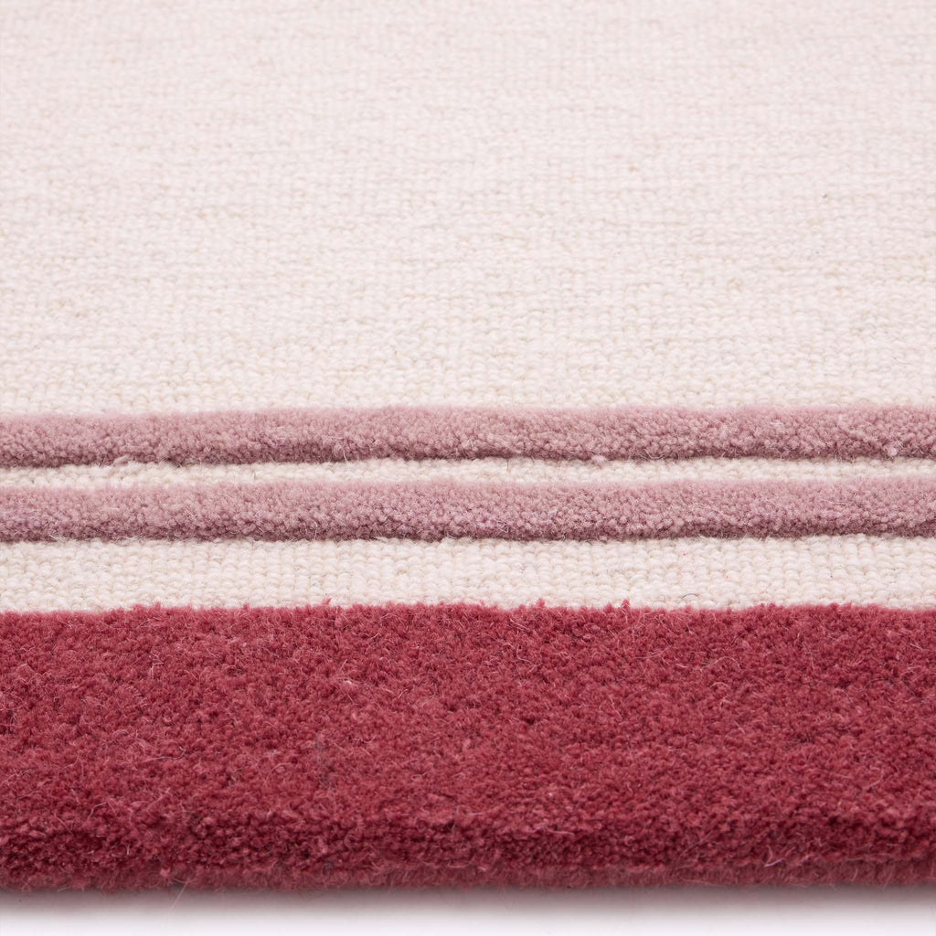 Piper Rug- a 100% wool rug with a raspberry border. 