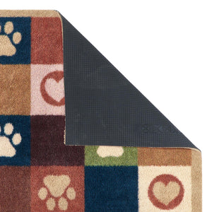 A close-up of a multicolor dog-themed doormat with a checkered pattern of paw prints, hearts, and paw pads in blue, brown, beige, and green, with the underside showing a dark gray textured non-slip backing.