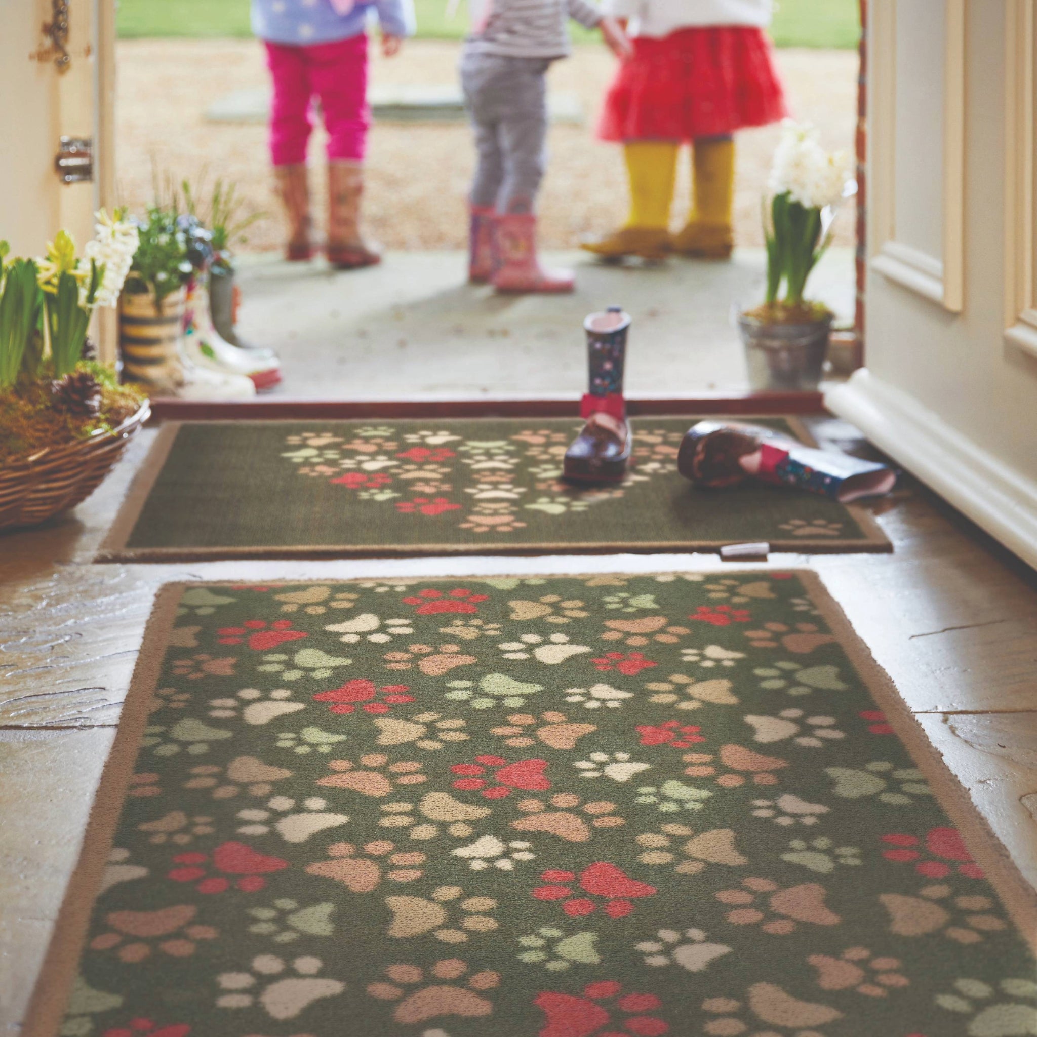Paws For Love Green Washable Doormat with a paw print love heart design, styled in a entryway.