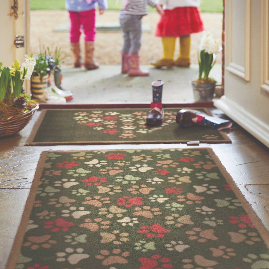  Paws for Love Washable Runner in Green- a 100% recycled cotton runner featuring multi-coloured paw prints in a multi-directional pattern.