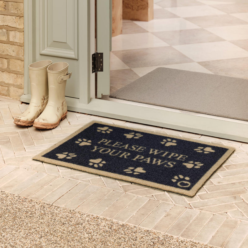 Pet 10 Blue Outdoor Recycled Doormat with paw prints and writing in the centre, styled in a doorway. 