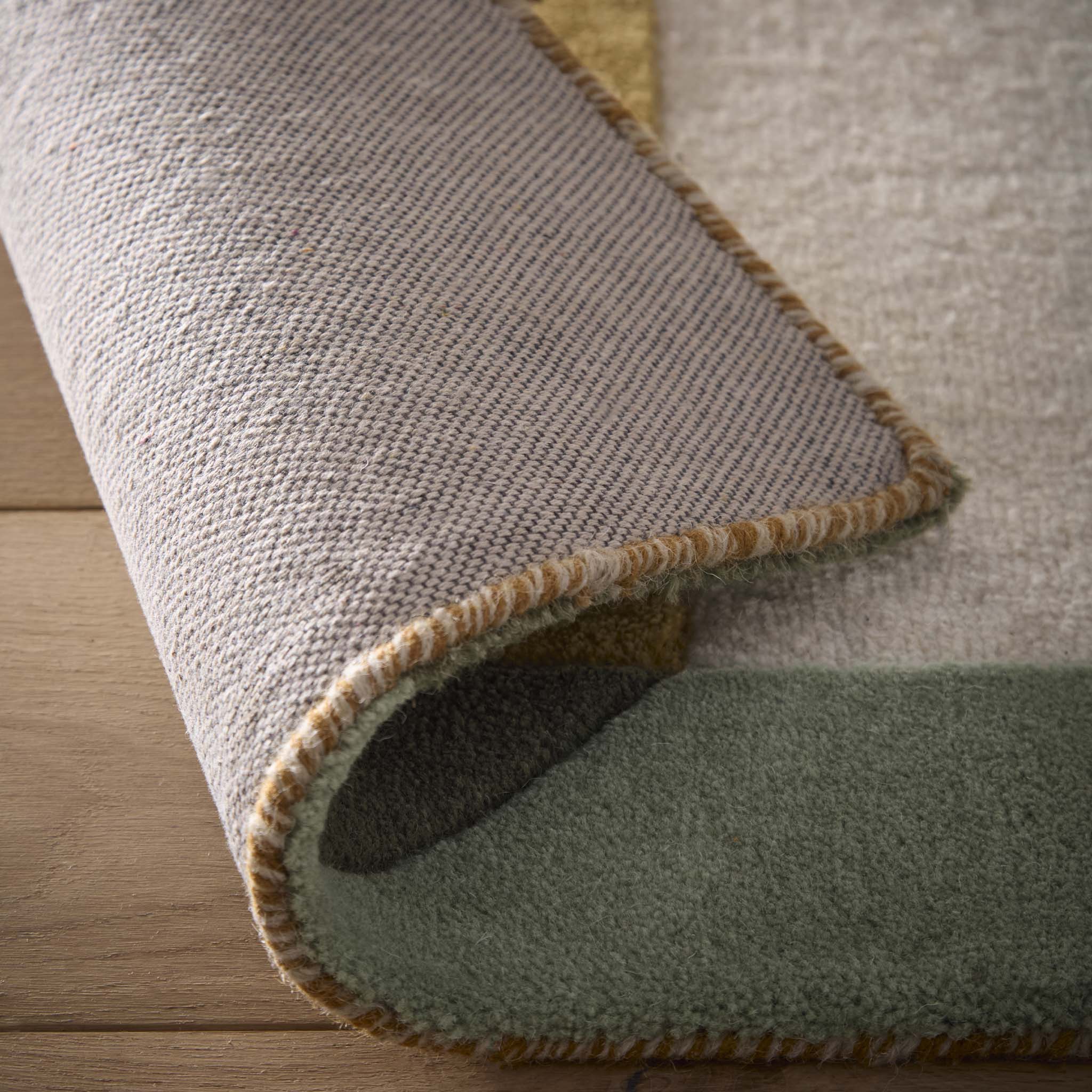 Close-up of Retro Deco Tan Wool Rug showing backing. 
