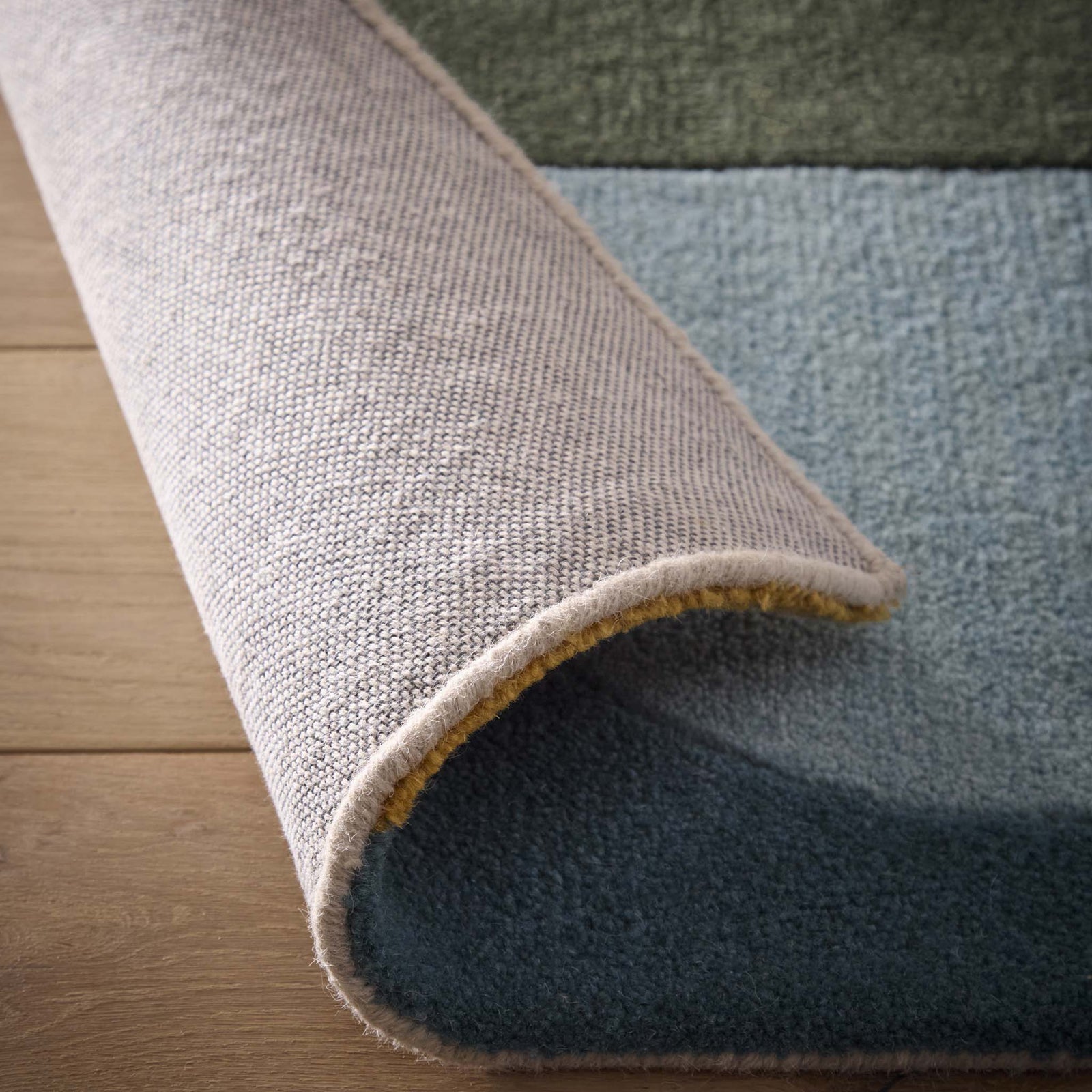 Close-up of Retro Deco Teal Wool Rug showing backing and carved geometric shapes.