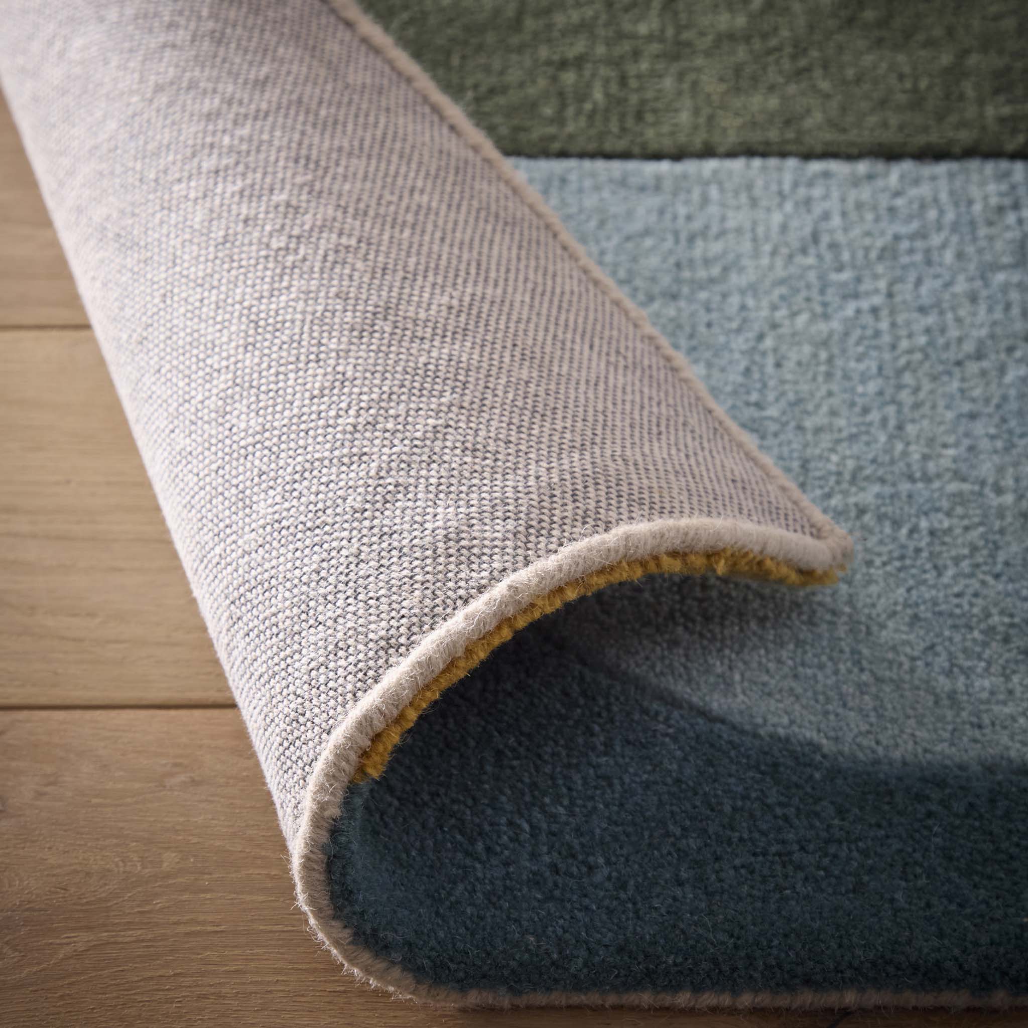 Close-up of Retro Deco Teal Wool Rug showing backing and carved geometric shapes.