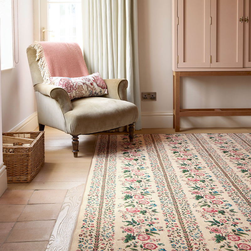Rose Pergola Chintz Eco-Washable Rug with a floral design, styled by a armchair. 
