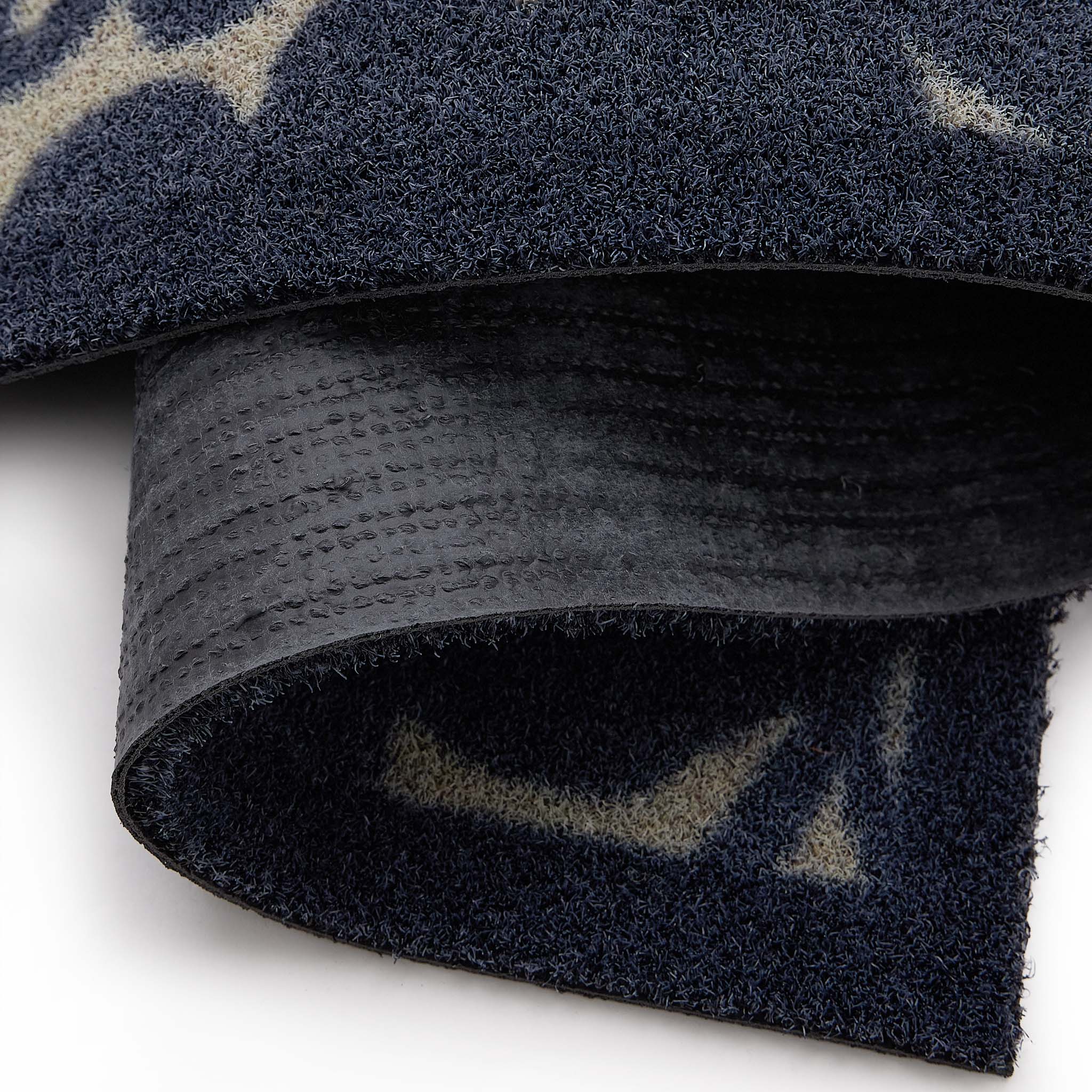 Kukkia Dark Navy Outdoor Doormat with a floral design, styled with backing showing.